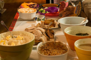 table set with various dishes of food and Thanksgiving decorations