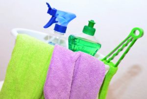 Cleaning supplies and washcloths in a bucket