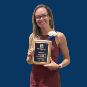 Olivia Patchel holding Distinguished Service Award