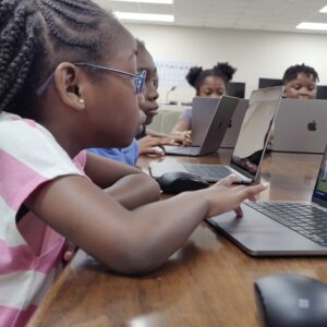 Kids using MacBooks to learn digital skills